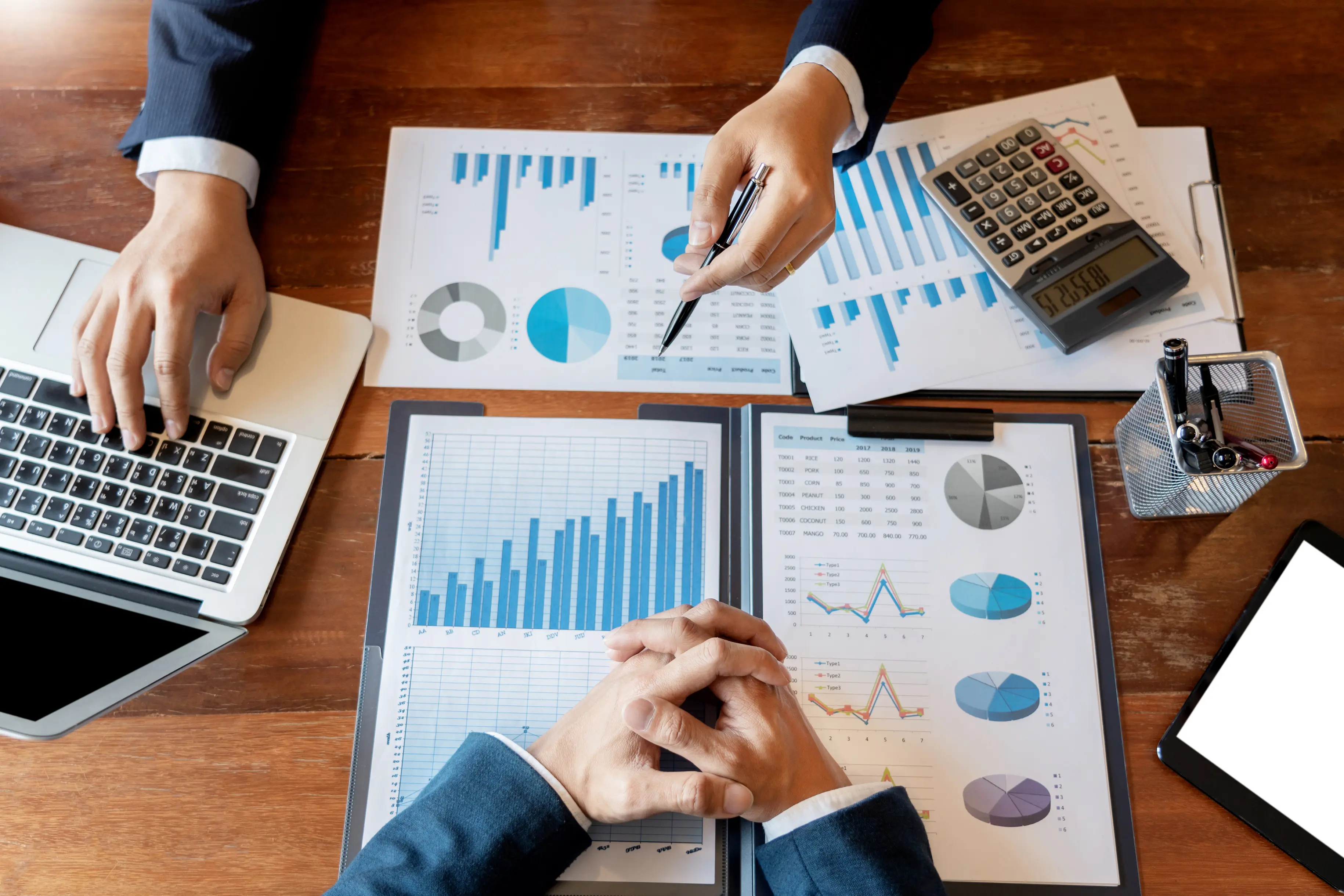 Meeting with data sheets, someone pointing at a laptop