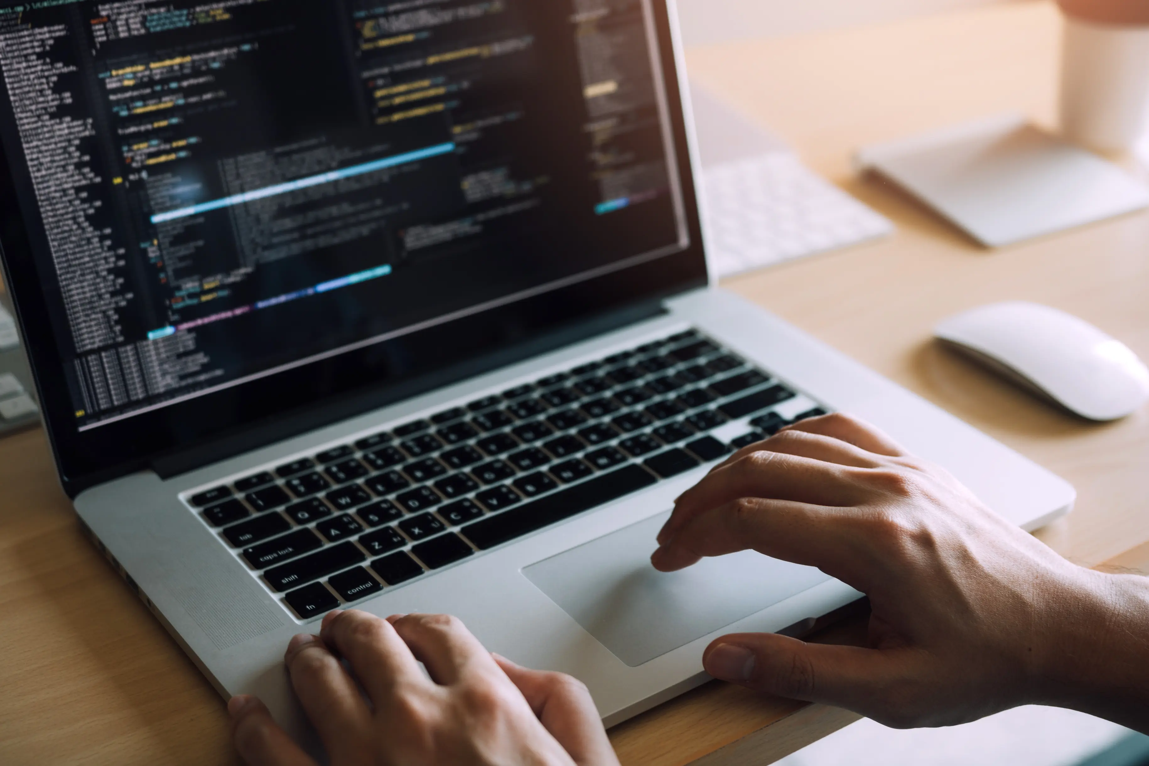 Person moving the cursor on a laptop showing code