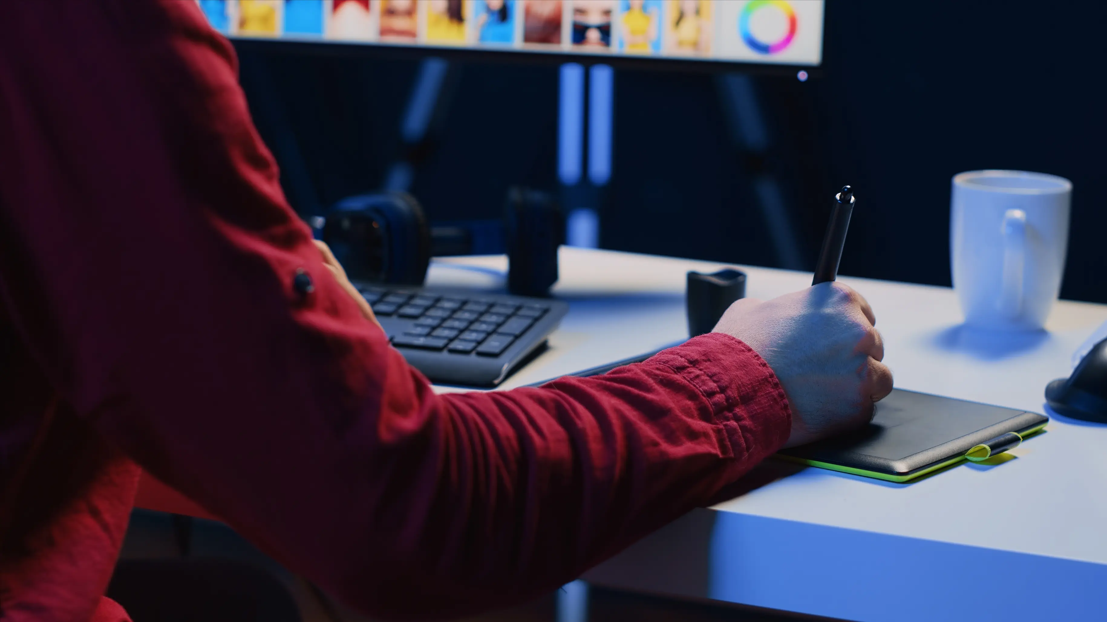 Person drawing on a pen tablet with coffee