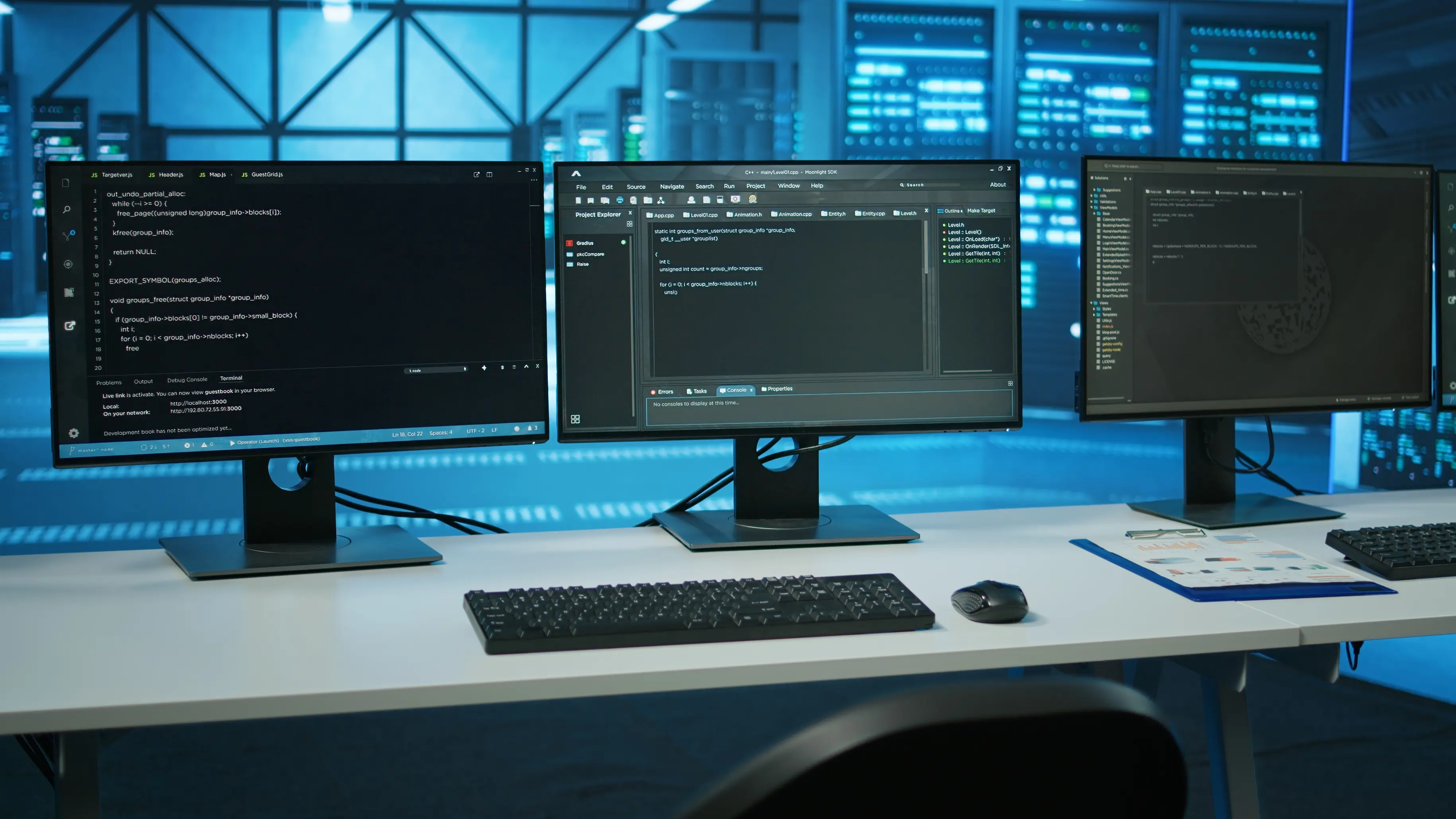 Tre skärmar med kod, sedda framifrån i ett datacenter