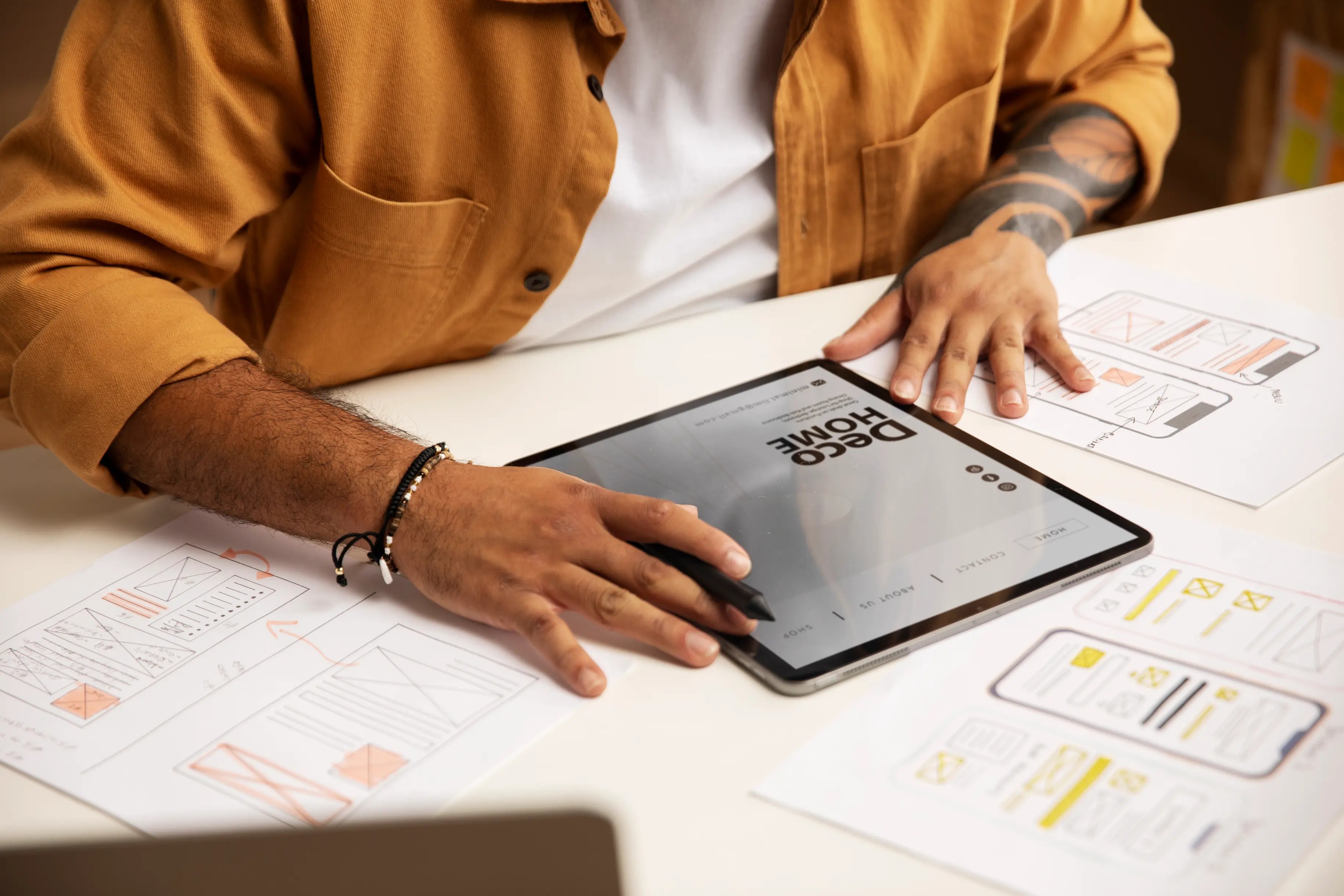 Person using a tablet and stylus for UI/UX design