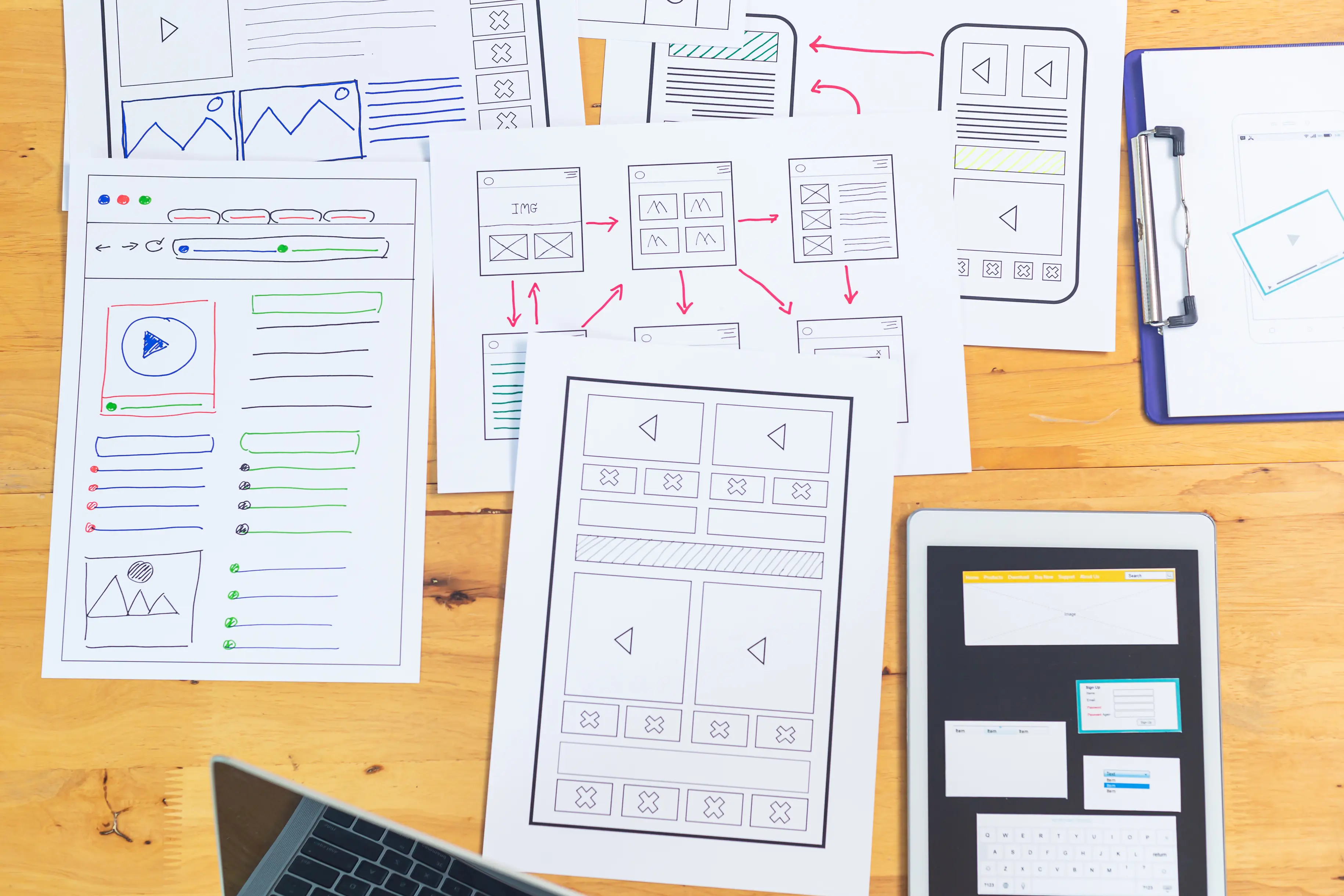 UI/UX design sheets spread on a table